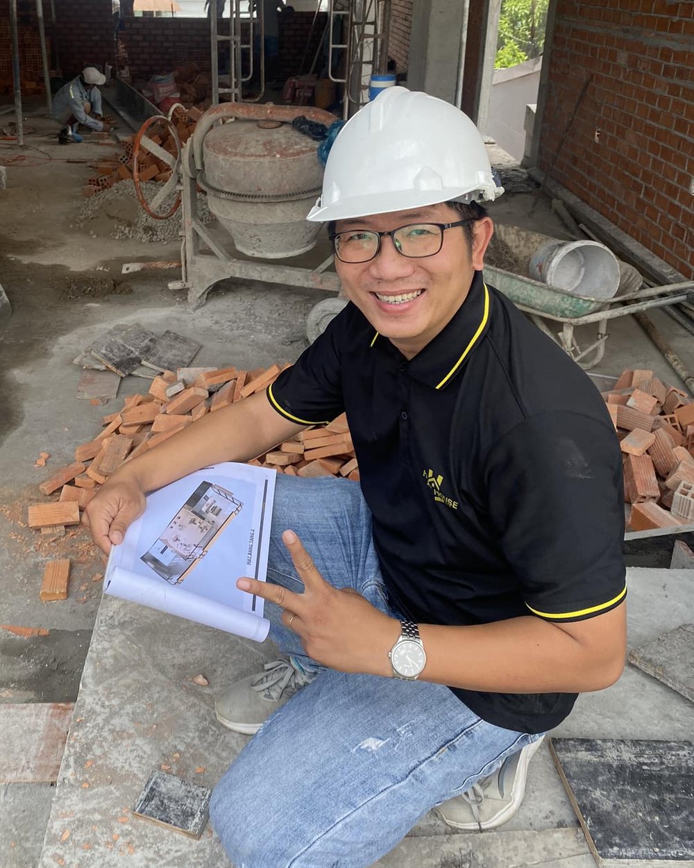 KS. Ngô Đình Khuôn đội nón bảo hộ, ngồi xem bản vẽ tại công trình nhà ở đang xây phần thô