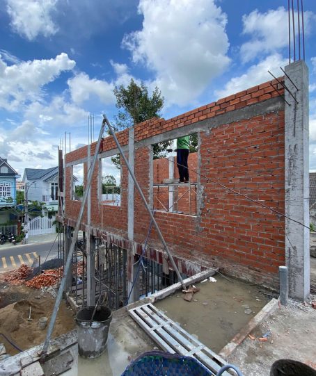 Nhà phố đang xây phần thô, tường gạch đỏ với các ô cửa chờ